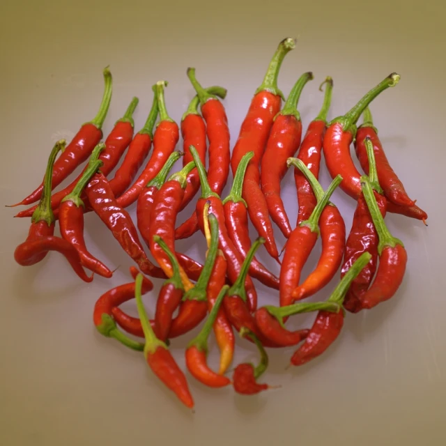 a pile of red peppers sitting on top of a table