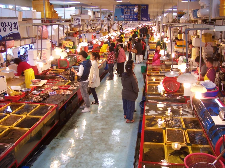 a crowded supermarket store filled with people shopping for goods