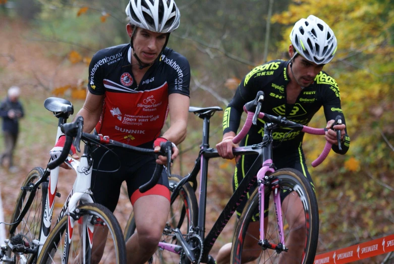 two people on bikes on the street in the woods