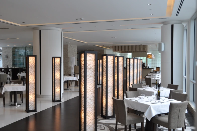 a white restaurant with fancy lighting and tables