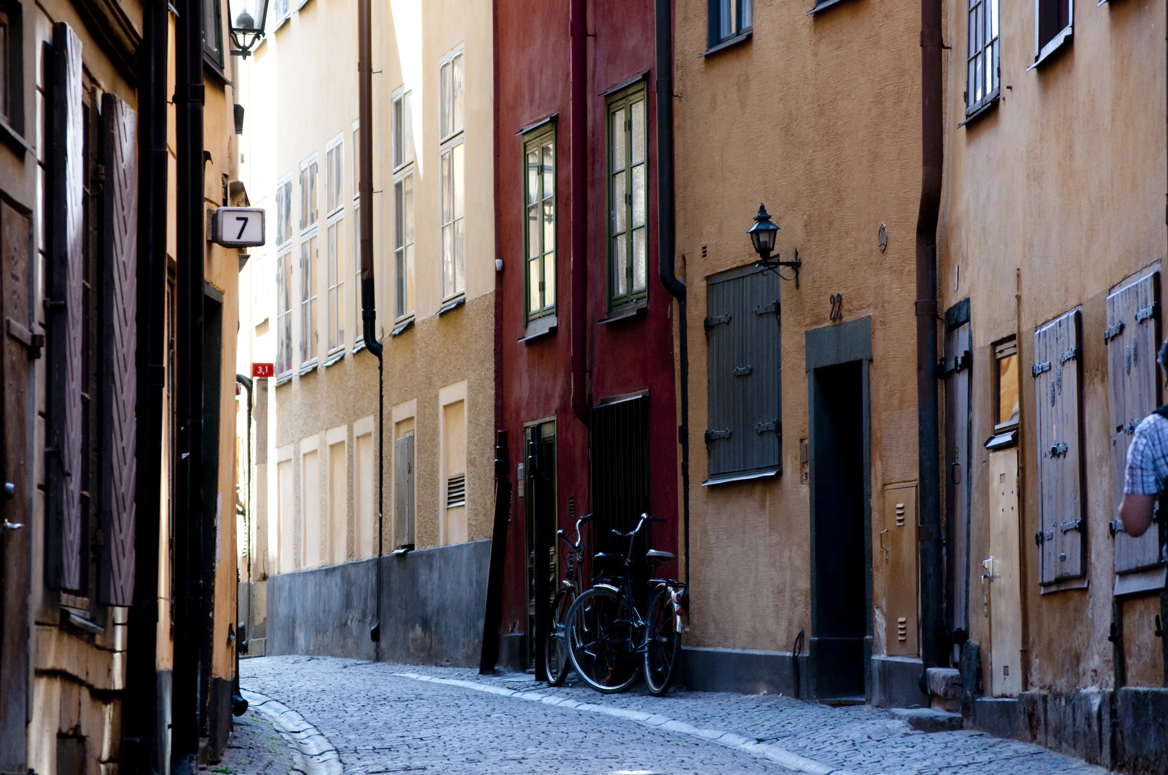 two bicycles are parked on the narrow street