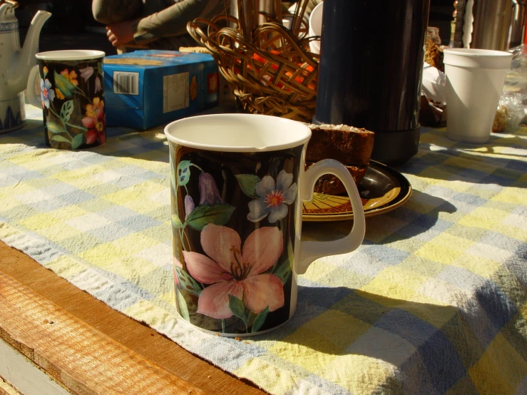 a mug is on the table and near a cake