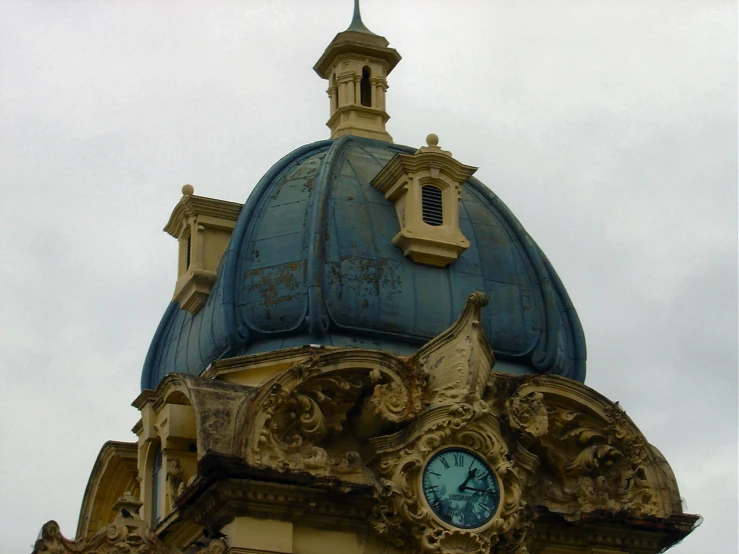 a dome roof with clocks on it and a blue sky behind