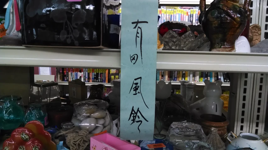 a chinese sign sitting in front of a shelf