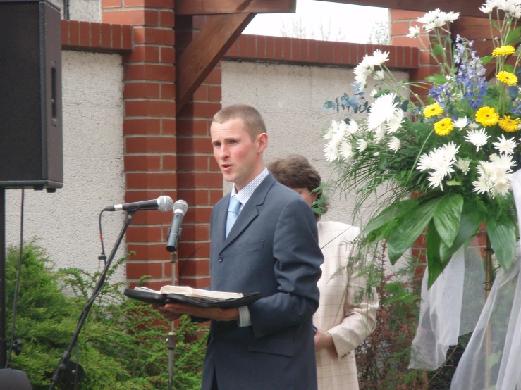 a man and woman are standing behind a wedding speaker
