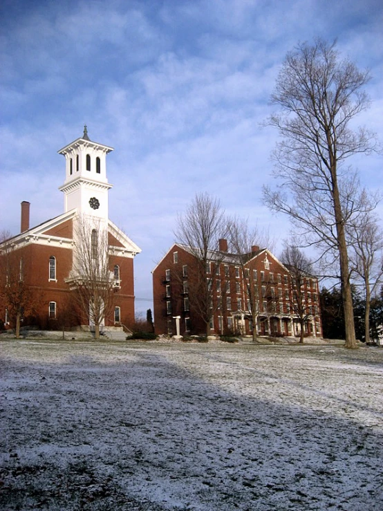 a snow - covered cam near trees and a building