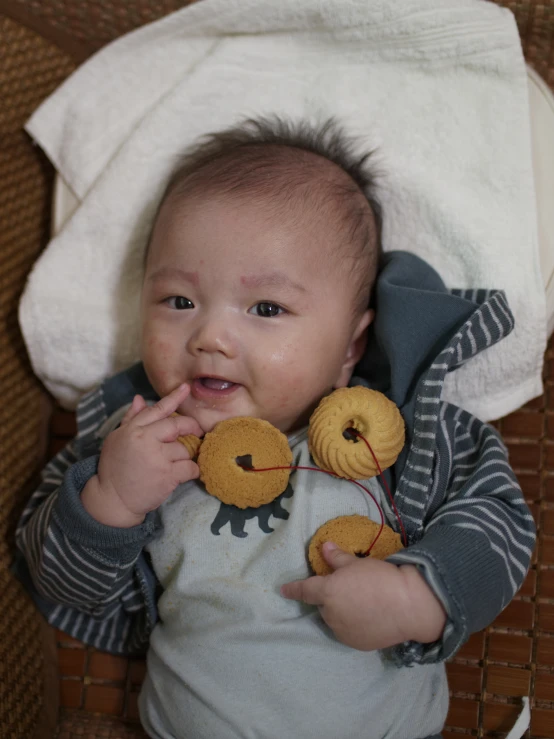 baby laying on bed with stuffed animal toy in mouth