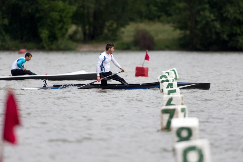 two men rowing in a large body of water