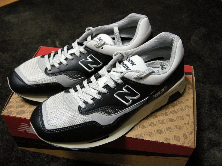 a pair of new balance 999 black, white and brown sneakers