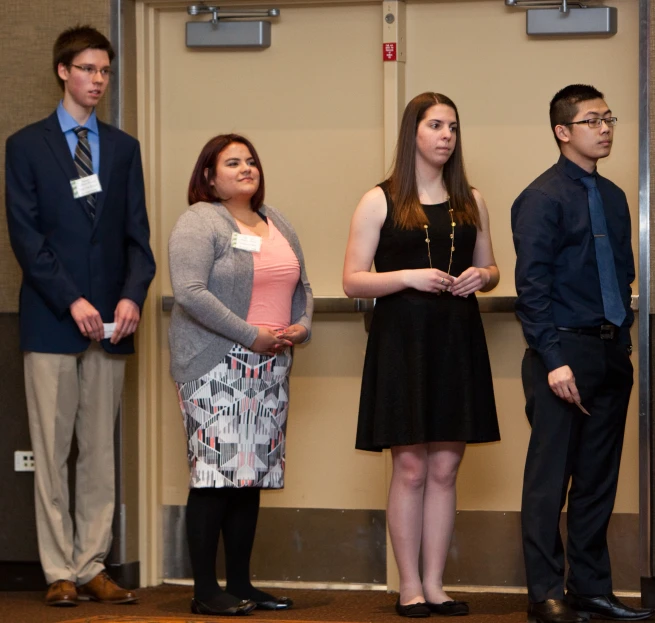 two men and two women are standing at the podium