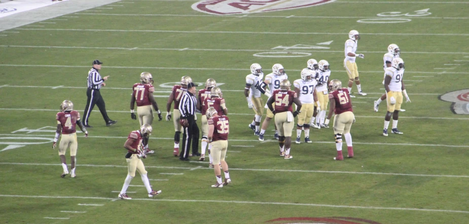 a football game in progress as the opposing team holds onto their uniforms