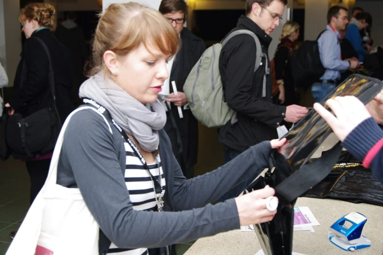 woman checking her ipad with others looking on