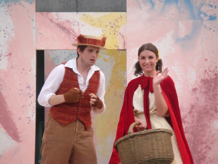 two people dressed up as renaissance musicians holding baskets