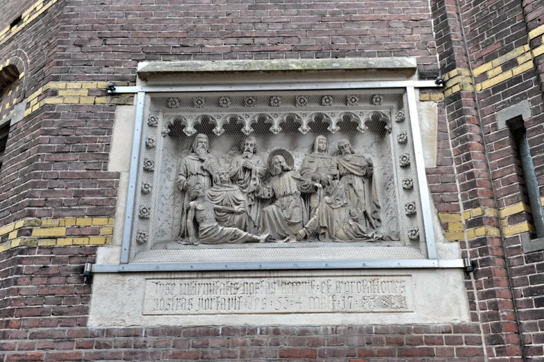 the plaque above the door of the church has statues on it