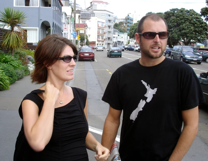 the man and woman walk down the city street