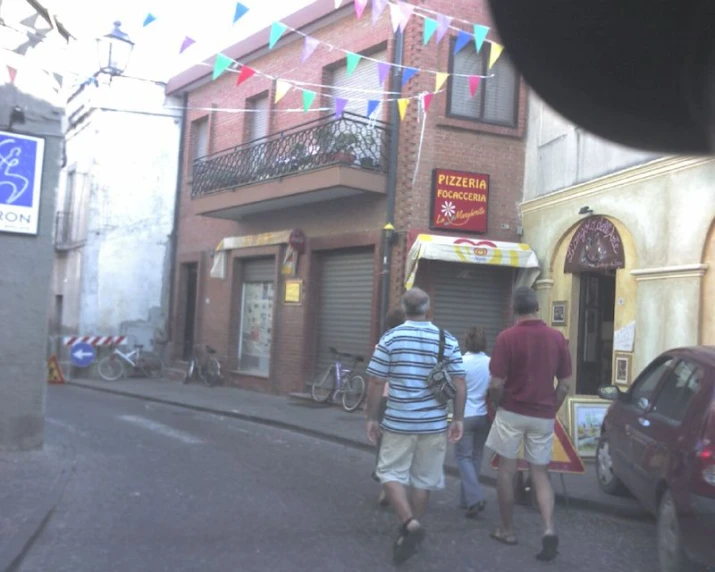 two men walk down the street in front of an apartment building