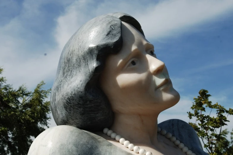 a statue of an old woman is standing outside