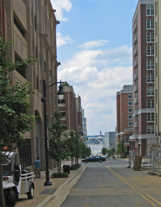 a street lined with tall buildings and parked cars