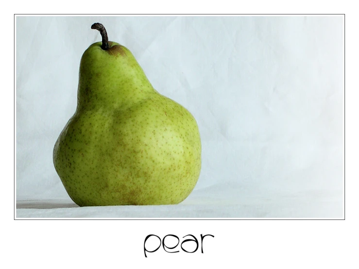 a green pear sitting on top of a white table