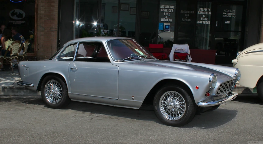 a silver car parked in front of a store