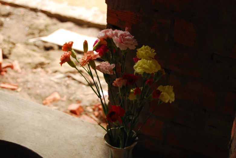 vase of cut flowers with brick wall in the background