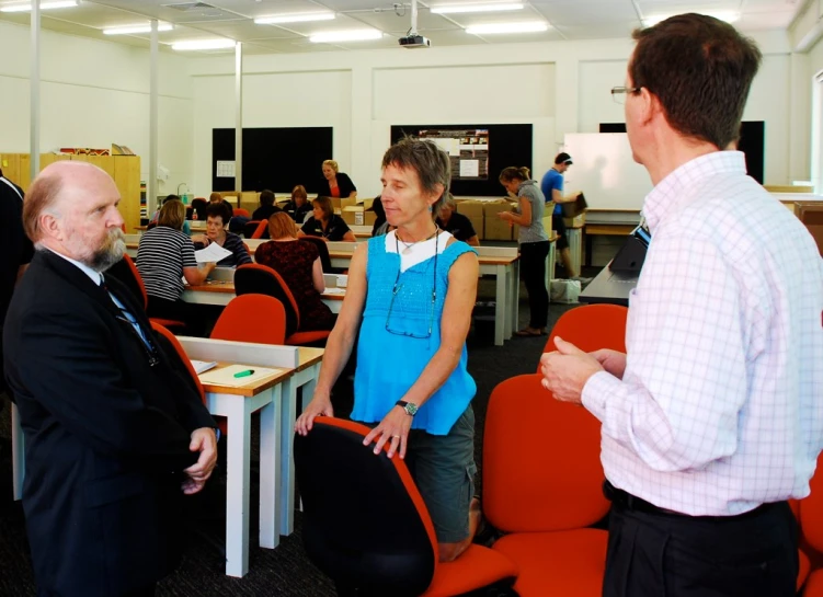 several people at tables discussing with one man