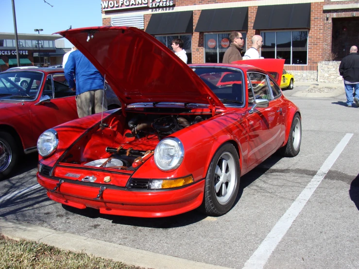 two red sports cars are parked in a parking lot