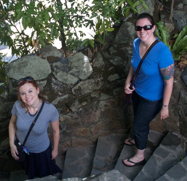 two people standing on the steps of a stone structure