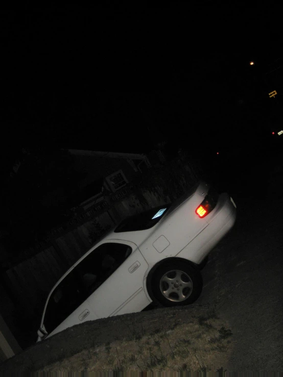 a white car is laying upside down in the street