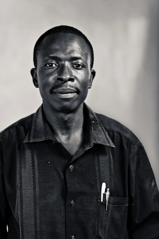 a man poses in a black shirt in a room