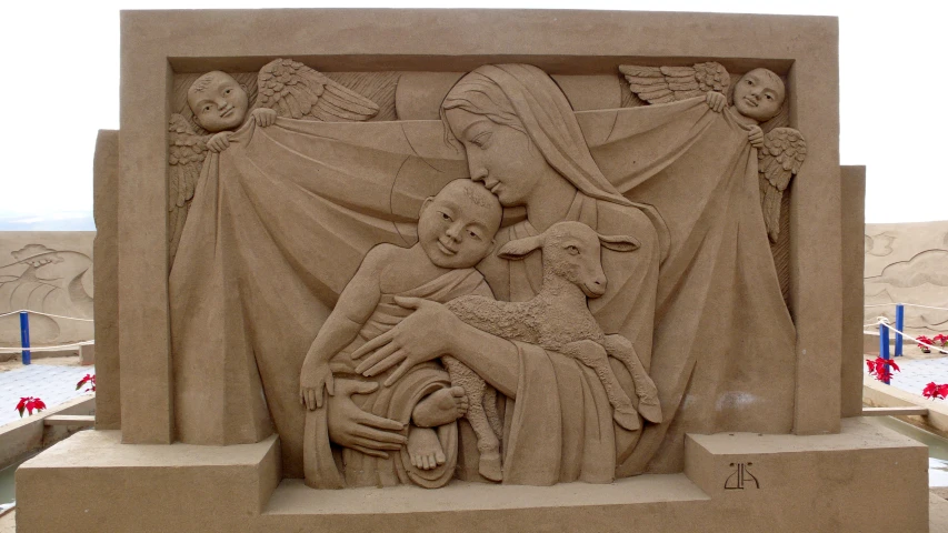 an elaborate sand sculpture with a child and mother holding a child