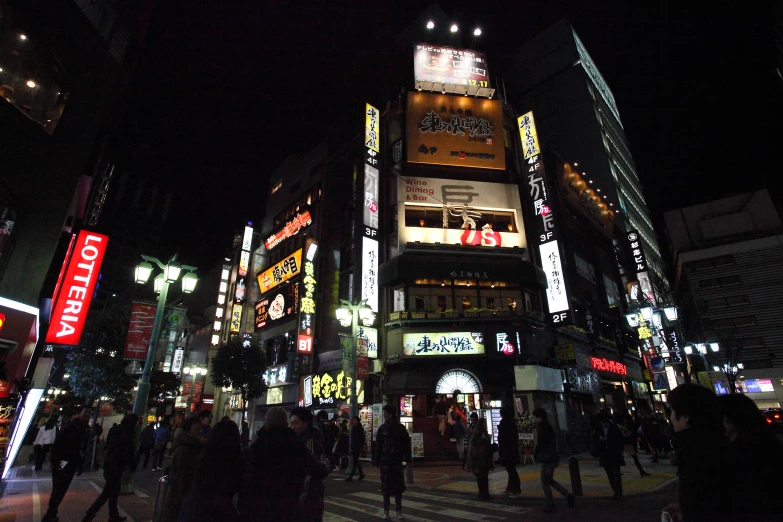 a group of people crossing the street at night time