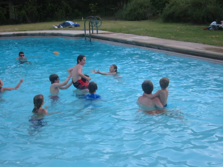 some children play in the pool with an adult