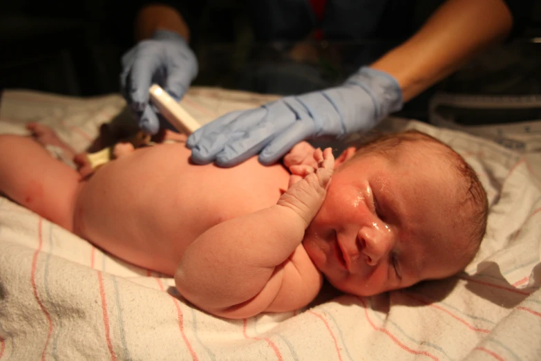 an infant is being checked up by medical personnel