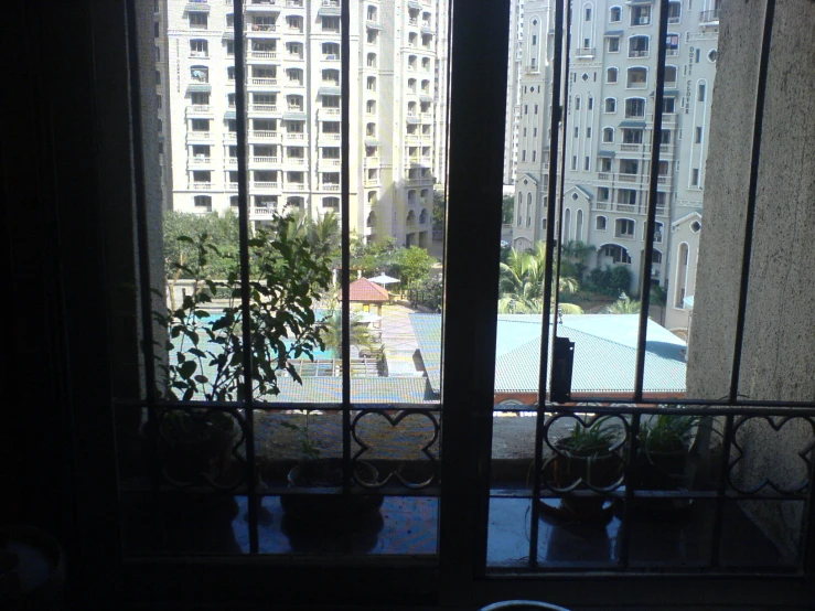 view of an outdoor pool from inside a glass walled building