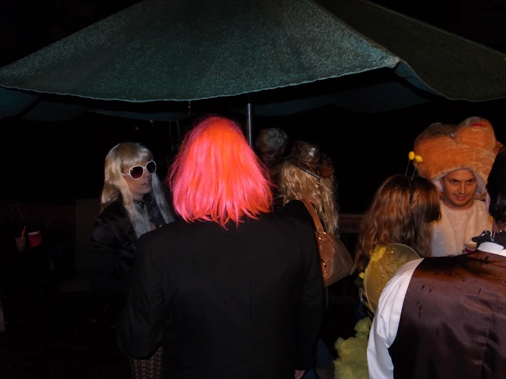 a bunch of people wearing costume outside with umbrellas