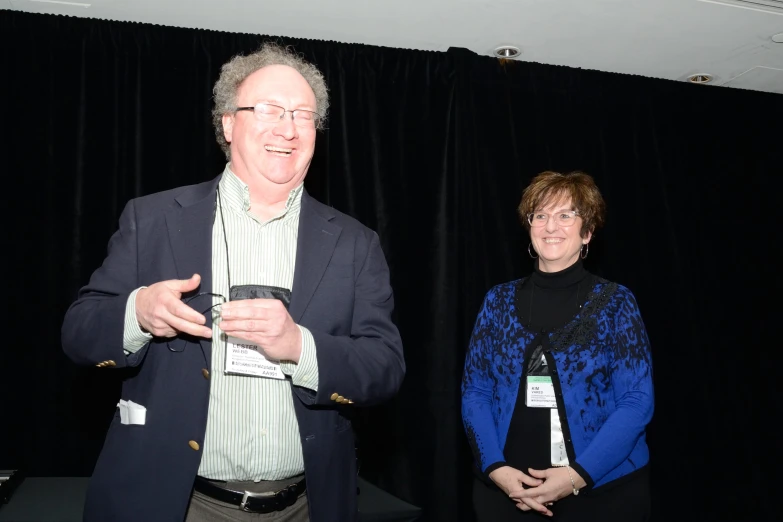 two people standing next to each other while holding remotes