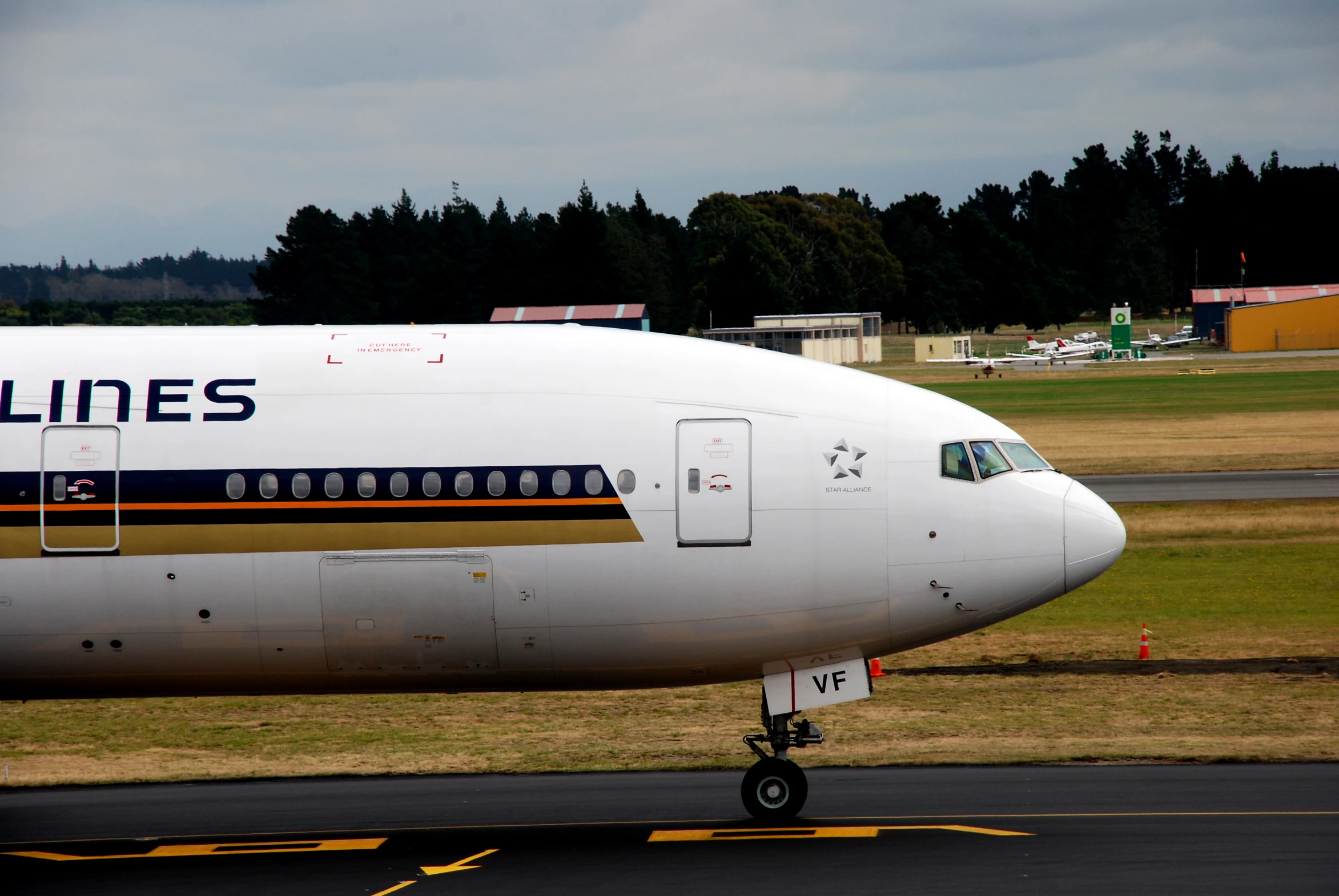 a white plane on the ground with trees in the background