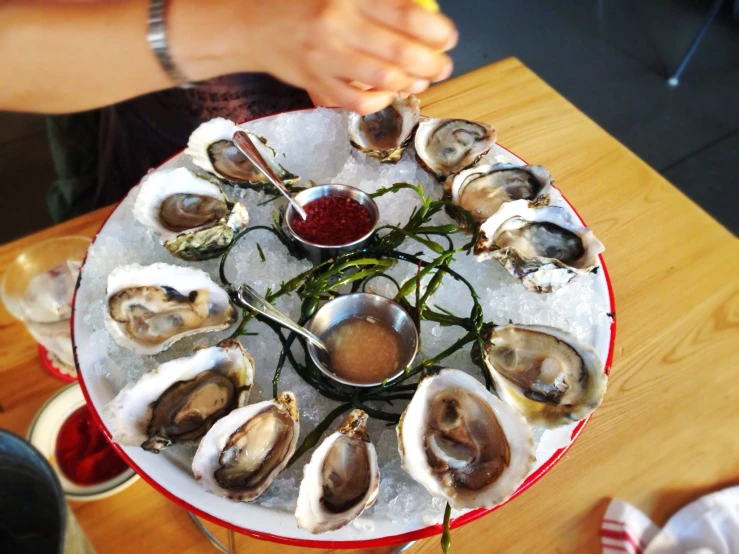 woman serving several oysters on ice to each other