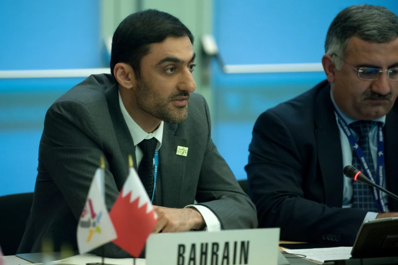 a man sitting at a table with flags on it