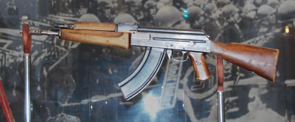 a replica of an automatic rifle displayed in glass