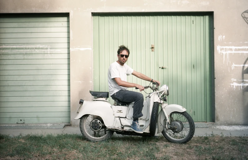 the man is posing for a pograph on his motorbike