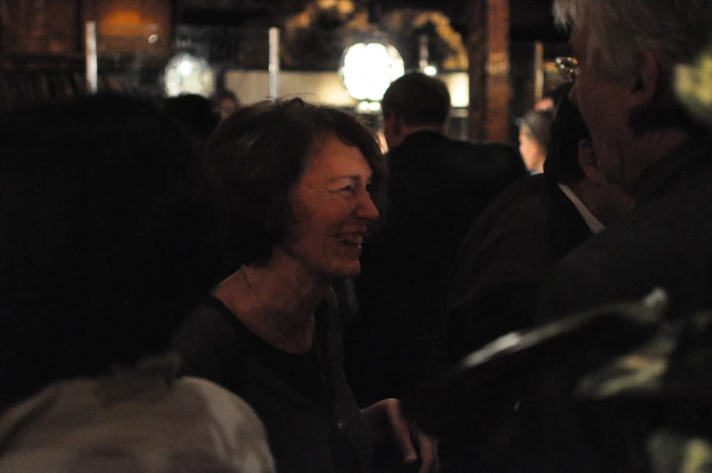 a woman standing next to a man in a dark bar