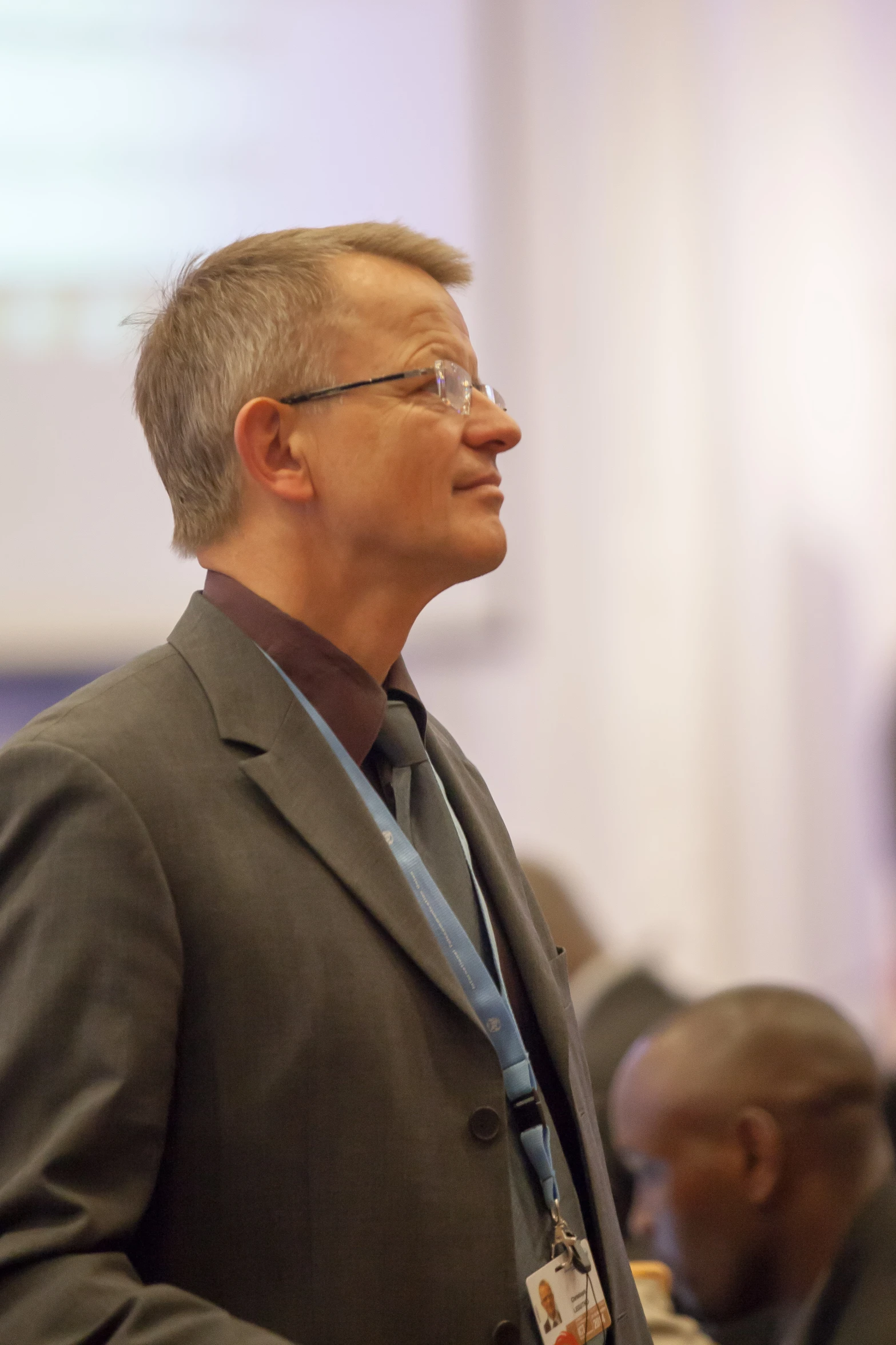 a man wearing glasses while standing in a room