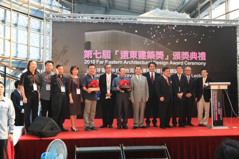 several people on stage with speakers and signs