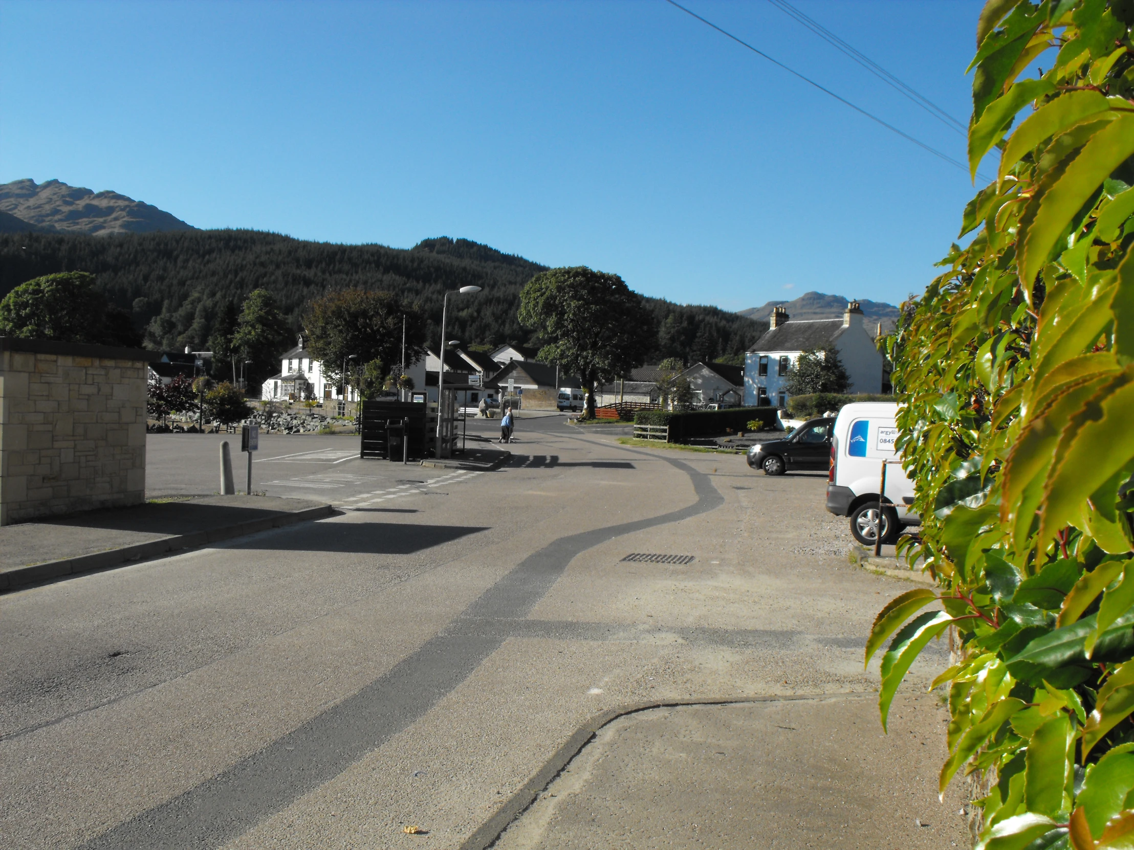 the cars are parked on the road near a street sign