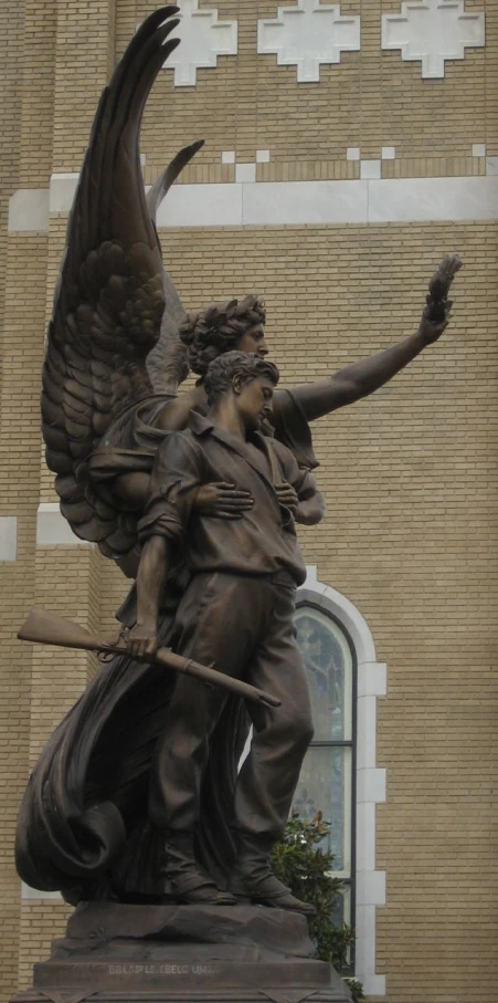 an angel holding a staff in front of a building