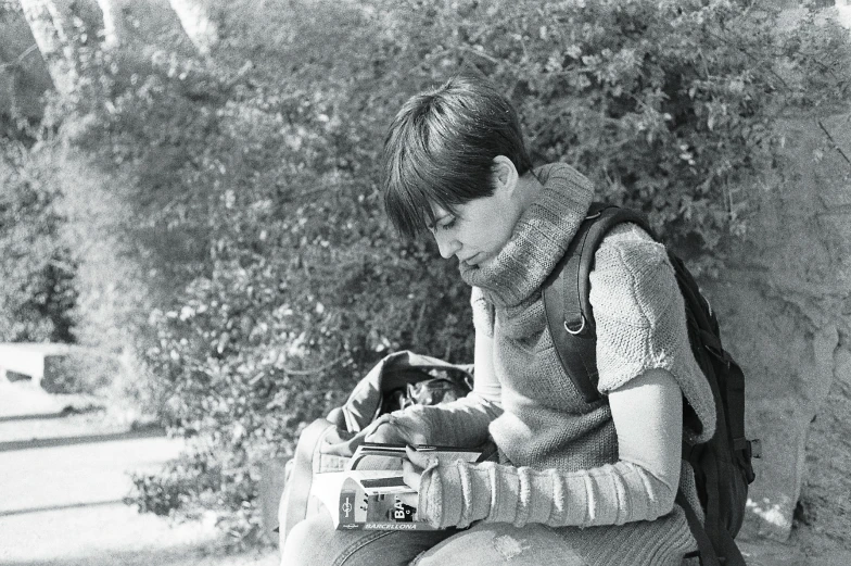 the boy is sitting on a stone and writing