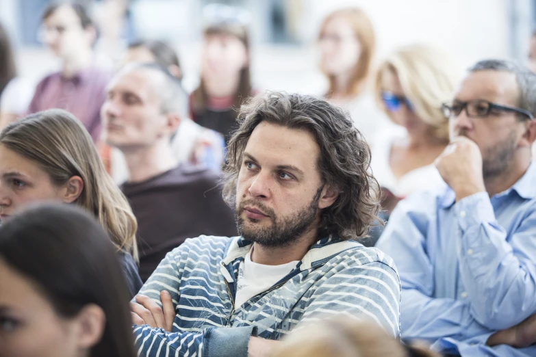 people seated in a room with one man looking at the camera