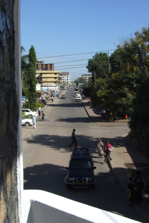 a view of a street with people walking in it